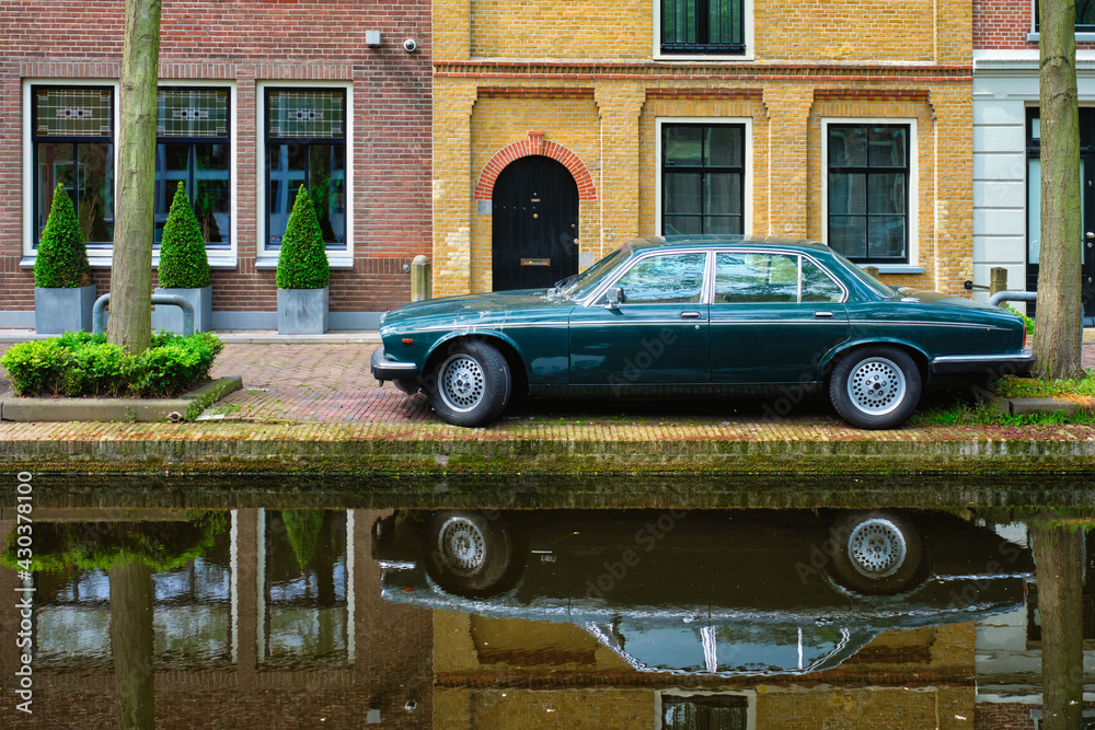 Old car on canal embankment in street of Delft. Delft, Netherlands Old car on canal embankment in street of Delft. Delft, Netherlands