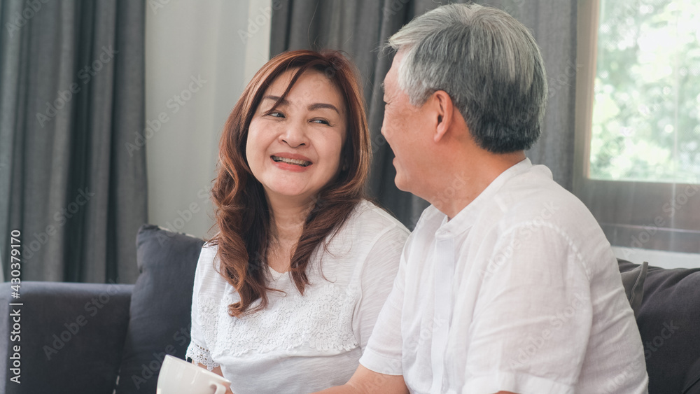 Asian senior couple relax at home. Asian Senior Chinese grandparents, husband and wife happy smile hug talking together while lying on sofa in living room at home concept. Asian senior couple relax at home. Asian Senior Chinese grandparents, husband and wife happy smile hug talking together while lying on sofa in living room at home concept.