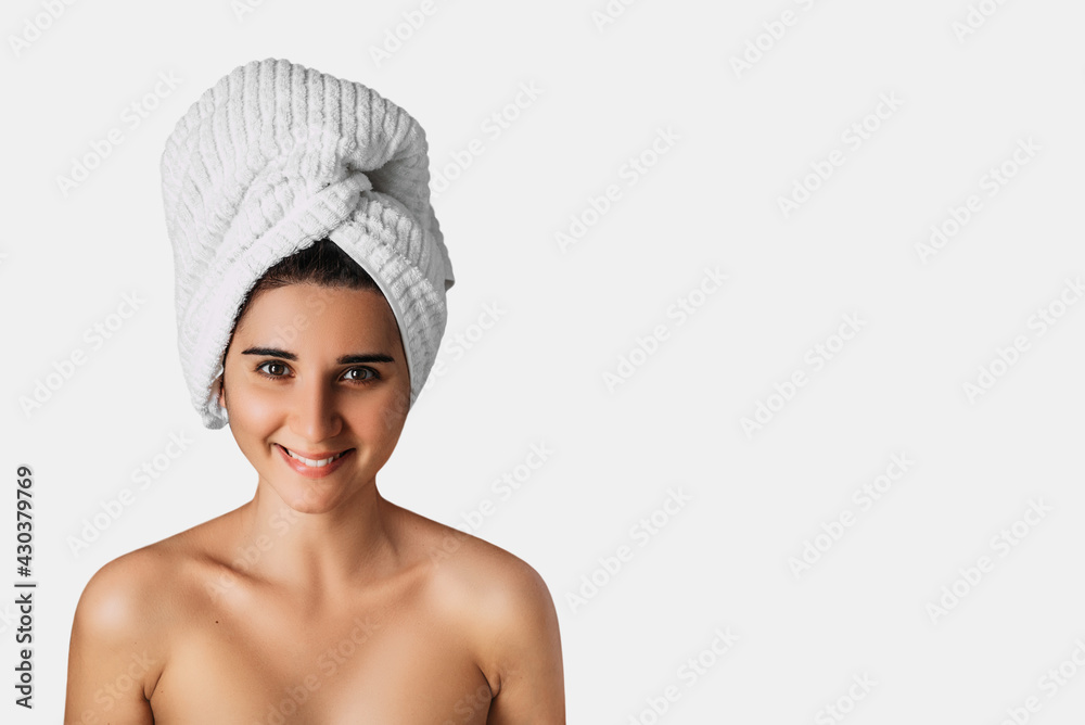 Portrait with copy space of charming pretty woman with beaming white smile after bath having towel on her head isolated on white background. Cosmetology , beauty and spa. Banner. Copy space Portrait with copy space of charming pretty woman with beaming white smile after bath having towel on her head isolated on white background. Cosmetology , beauty and spa. Banner. Copy space