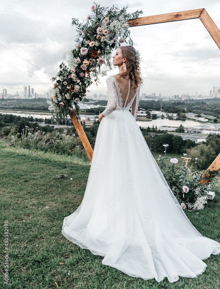 Fototapeta premium lovely beautiful young slender bride in an airy elegant white wedding dress with lace smile gentle portrait 