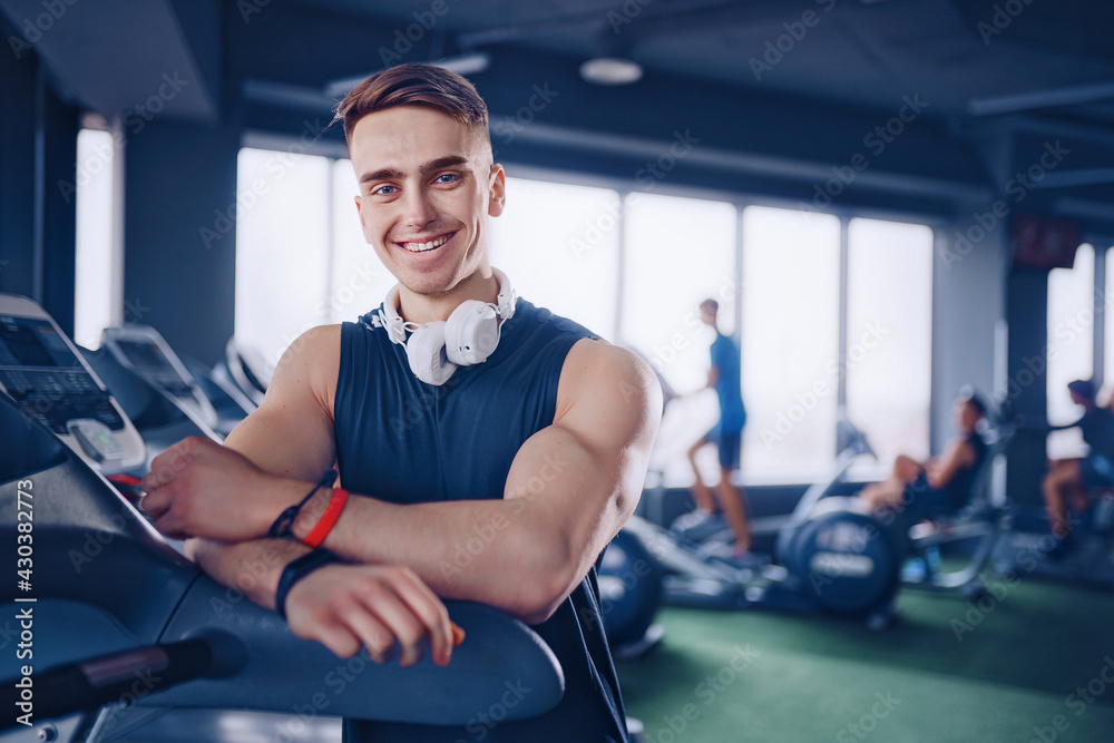 Smiling positive confident male personal instructor with arms cr Smiling positive confident male personal instructor with arms cr