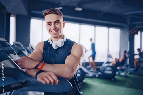 Smiling positive confident male personal instructor with arms cr