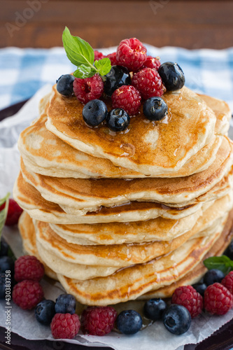 Pancakes with  honey and berries on blue background