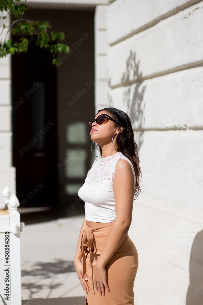 portrait of latin woman with sunglasses on the street enjoying a sunny spring day in europe
