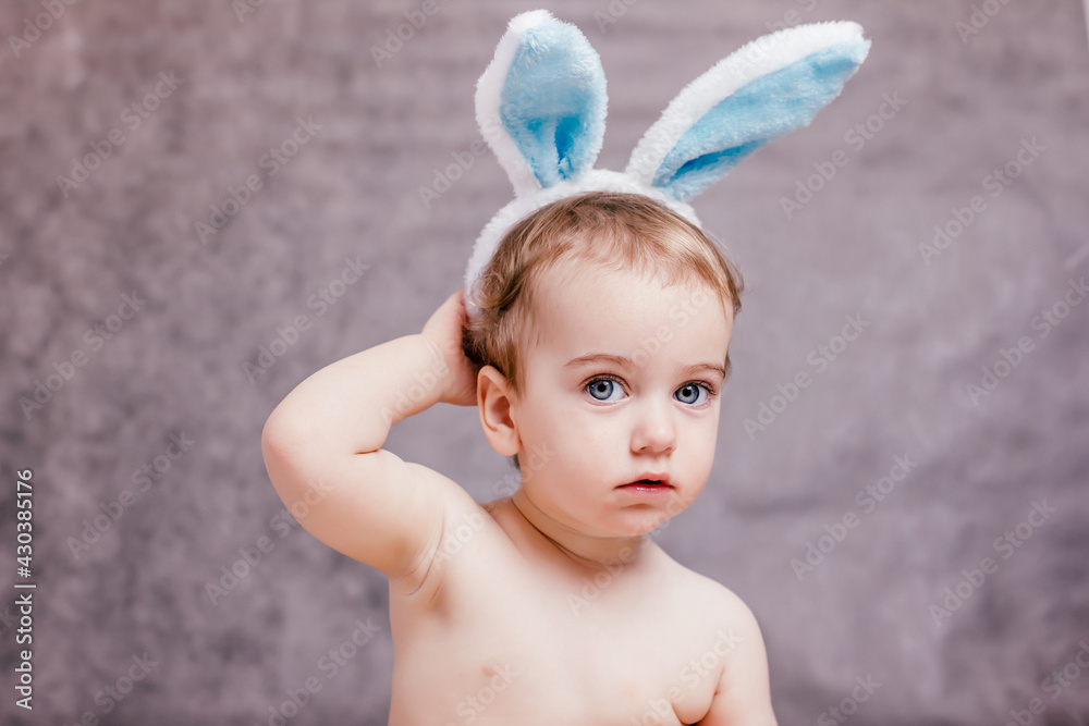 Cute baby in a blue bunny ears on gray background Cute baby in a blue bunny ears on gray background