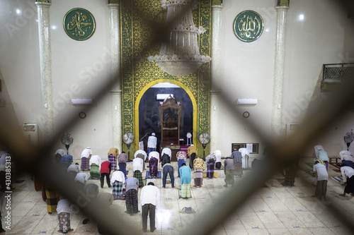 Situbondo, Indonesia - 26 April 2021 : indonesian muslim people (taraweeh) tarawih pray at Al Abror Mosque with social distancing photo