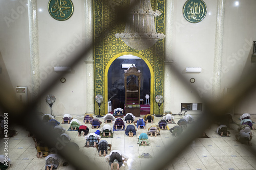 Situbondo, Indonesia - 26 April 2021 : indonesian muslim people (taraweeh) tarawih pray at Al Abror Mosque with social distancing photo