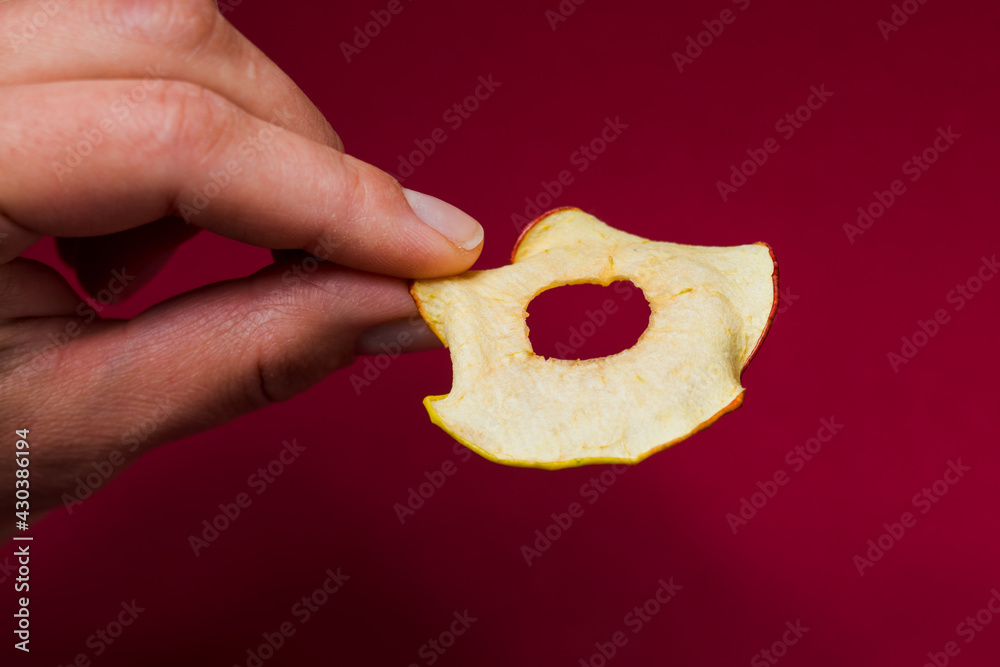 Woman hand take a round dried slice of apple Woman hand take a round dried slice of apple