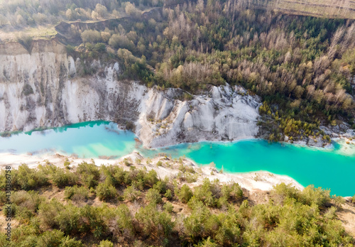 Fototapeta Naklejka Na Ścianę i Meble -  Artificial lake in a chalk quarry in Belarus at Krasnoselsky. Turquoise background of the clear water in summer season in open pit. Technogenic mountains formed during chalk mining. Amazing landscape