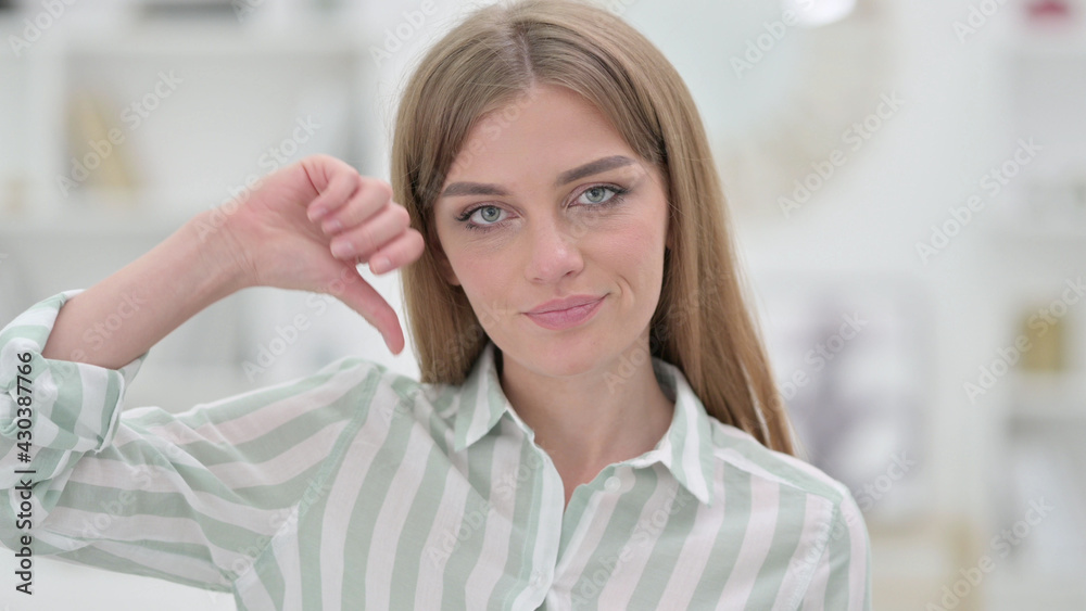 Portrait of Disappointed Young Woman doing Thumbs Down Portrait of Disappointed Young Woman doing Thumbs Down