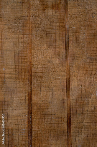 An old worn board with lines and cracks and an orange hugh makes a nice texture or background for a rustic style display.