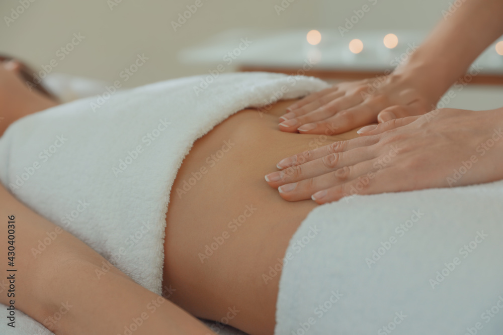 Woman receiving professional belly massage in wellness center, closeup - obrazy, fototapety, plakaty 