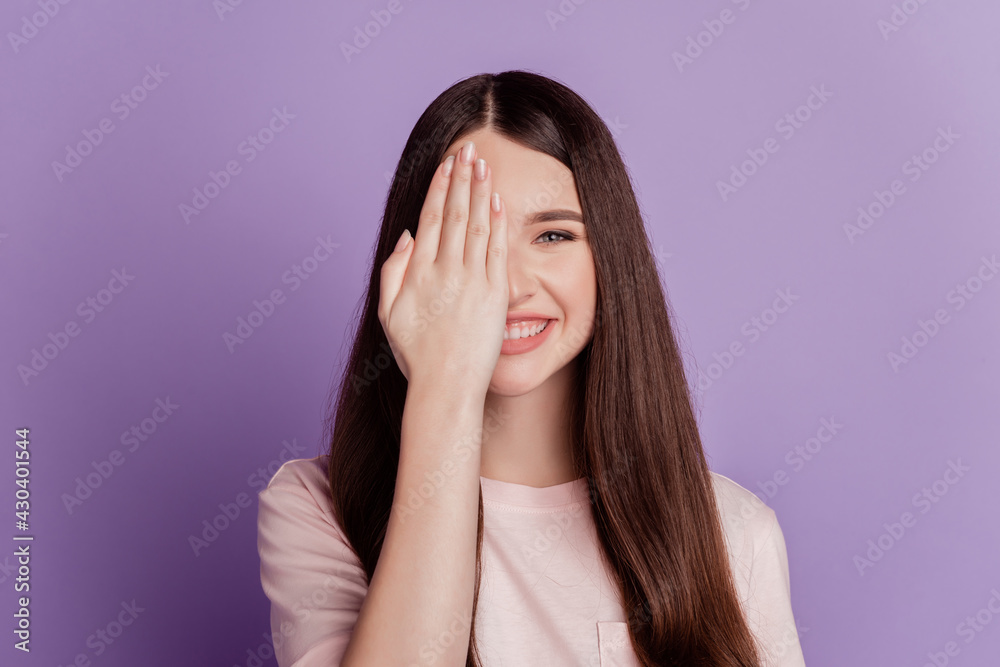 Portrait of happy woman palm cover eye watch toothy smile isolated on purple background Portrait of happy woman palm cover eye watch toothy smile isolated on purple background
