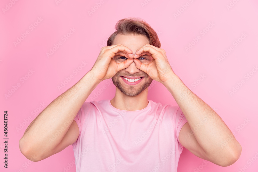 Photo of pretty playful young guy wear casual clothes showing arms spectacles smiling isolated pink color background Photo of pretty playful young guy wear casual clothes showing arms spectacles smiling isolated pink color background