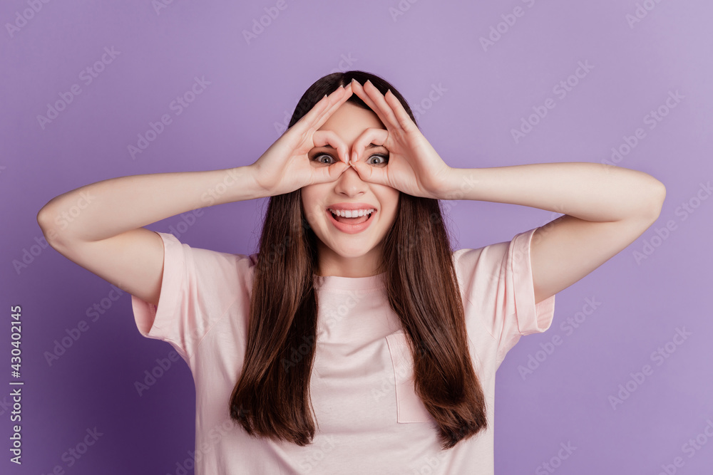 Portrait of funny young woman showing Ok sign cover eyes