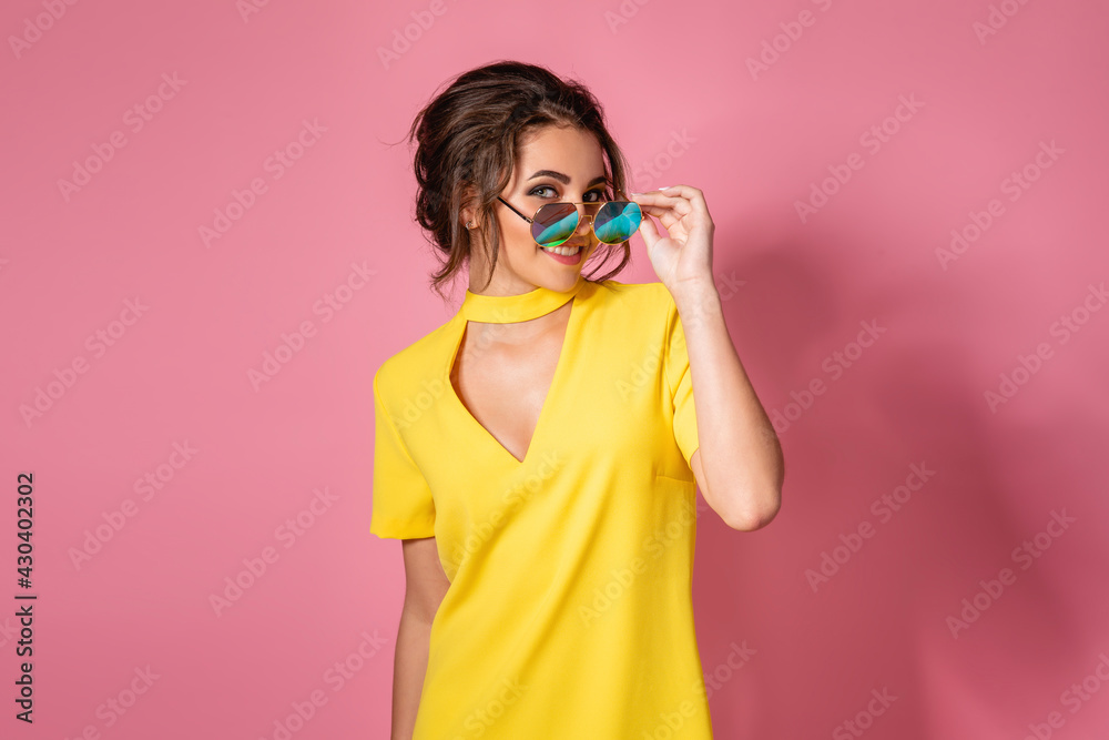 Beautiful girl in yellow dress wearing sunglasses posing, smiling on ...