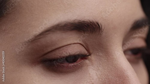 Close up of Caucasian Female crying with tear. Close Up Macro Zoom Shot of a Crying Eyes. Tears are Flowing Down. Young Beatiful brunette woman crying. Girl eyes having long nice Eyelashes.