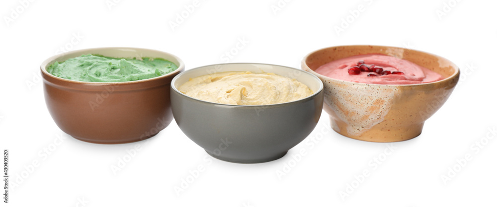 Different kinds of tasty hummus in bowls on white background Different kinds of tasty hummus in bowls on white background