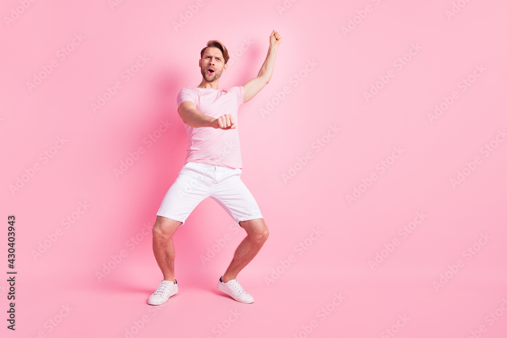 Photo of cute funky young gentleman dressed casual t-shirt dancing showing cowboy riding horse isolated pink color background Photo of cute funky young gentleman dressed casual t-shirt dancing showing cowboy riding horse isolated pink color background