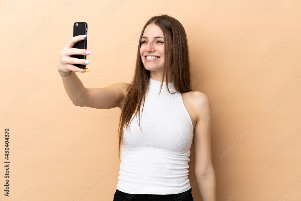 Young caucasian woman isolated on beige background making a selfie Young caucasian woman isolated on beige background making a selfie