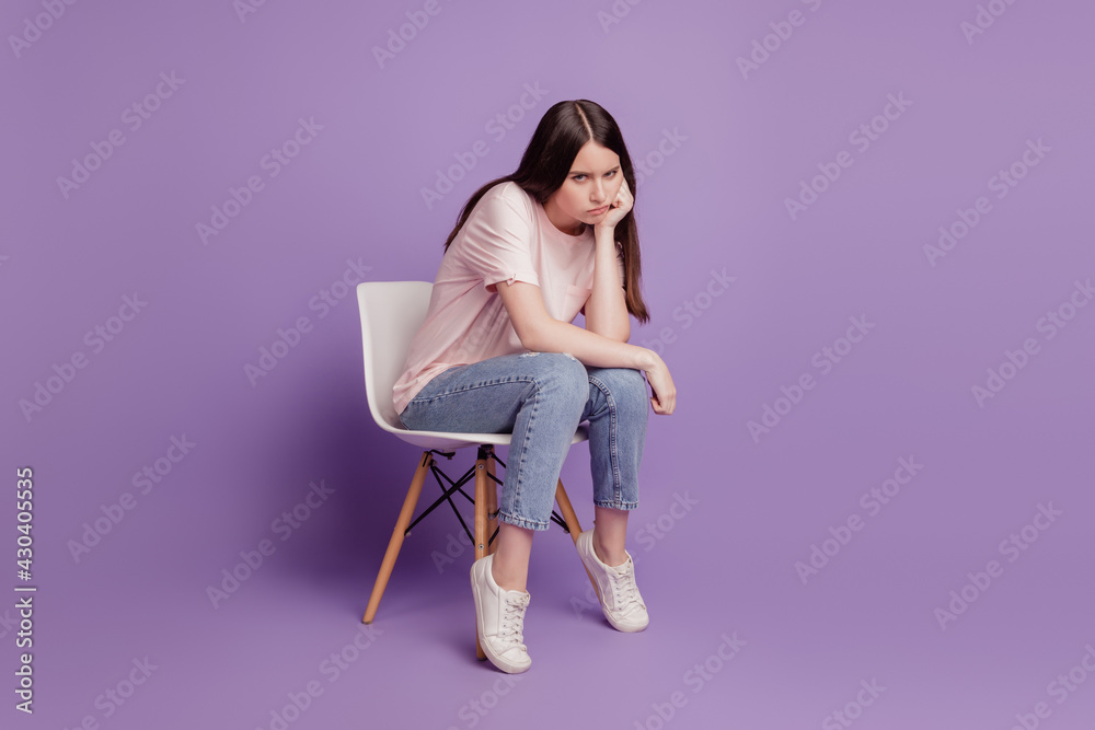 Portrait of sad unhappy frustrated desperate mood sit chair woman isolated on purple background Portrait of sad unhappy frustrated desperate mood sit chair woman isolated on purple background