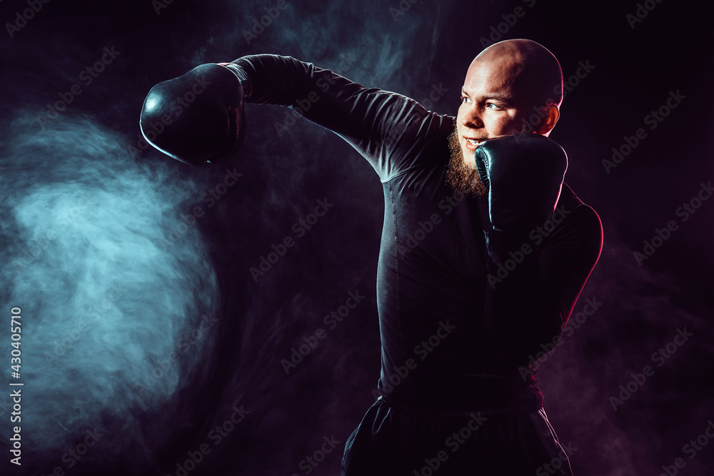 Sportsman boxer training, hitting side impact on black backgroun