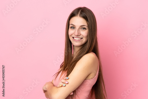 Young caucasian woman isolated on pink background with arms crossed and looking forward