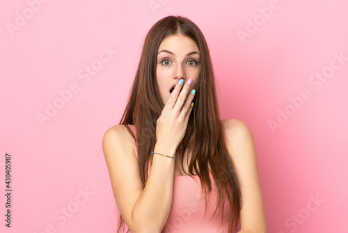 Young caucasian woman isolated on pink background surprised and shocked while looking right