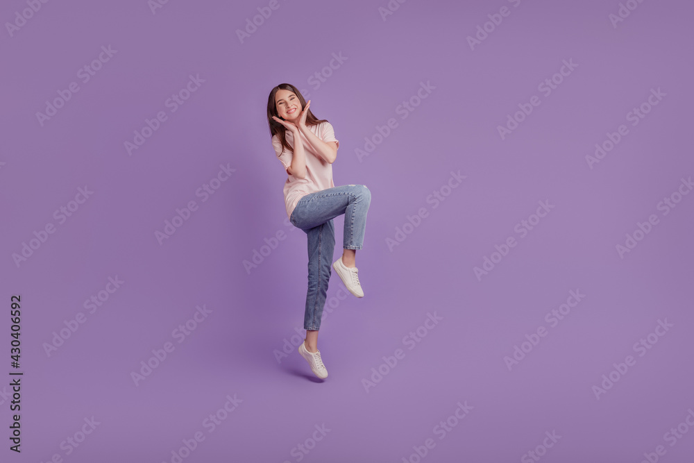 Portrait of adorable tender girl jump girlish posing on purple wall