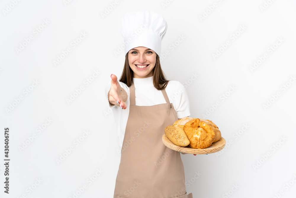 Young woman in chef uniform isolated on white background handshaking after good deal Young woman in chef uniform isolated on white background handshaking after good deal