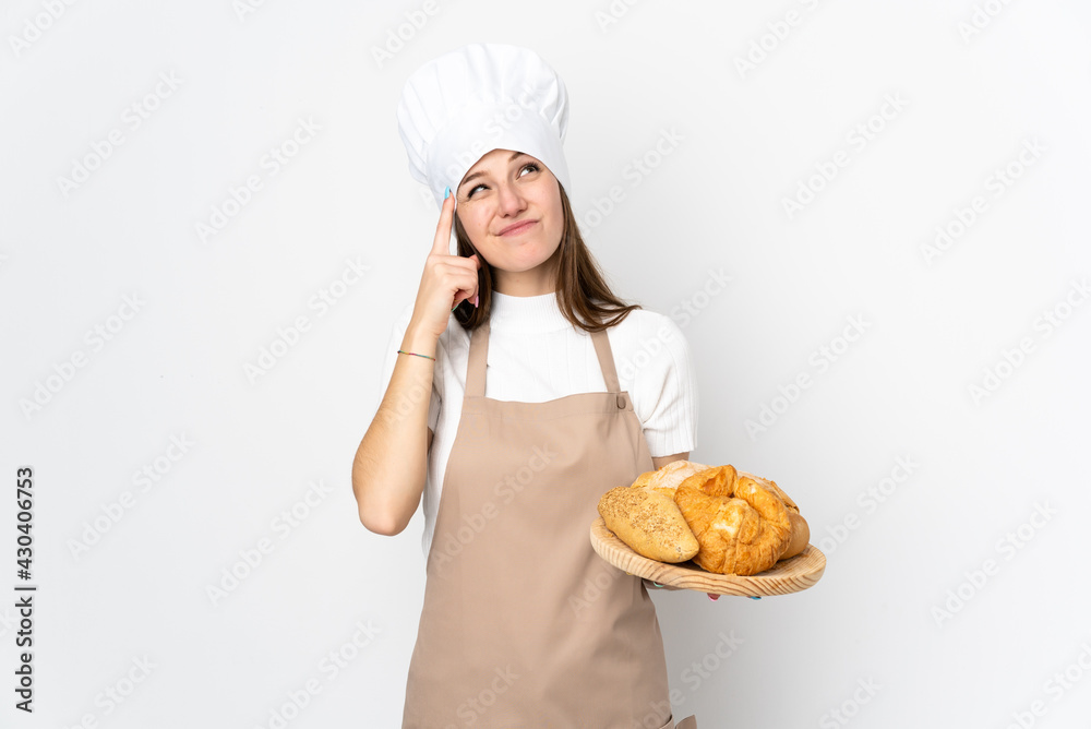 Young woman in chef uniform isolated on white background having doubts and with confuse face expression Young woman in chef uniform isolated on white background having doubts and with confuse face expression