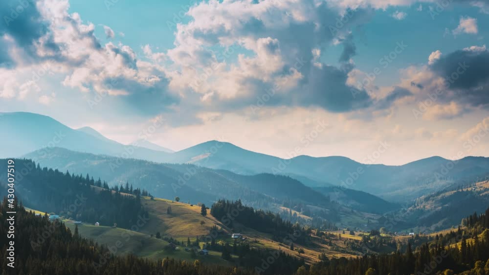 Summer landscape time lapse. Clouds passing in blue sky over mountain range with sun beams emerging through the clouds
Summer landscape time lapse. Clouds passing in blue sky over mountain range with sun beams emerging through the clouds
