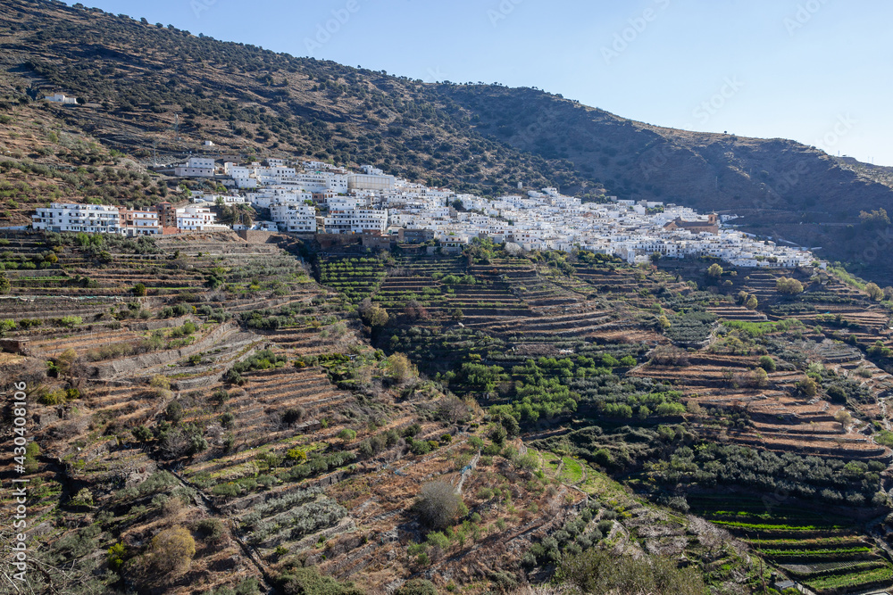 View across white village on the slope of mountain in the Sierra Nevada, Las Alpujarras, Granada Province, Spain