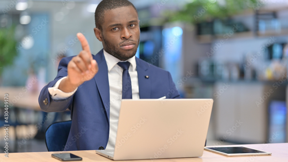 African Businessman with Laptop showing No Sign in Office African Businessman with Laptop showing No Sign in Office