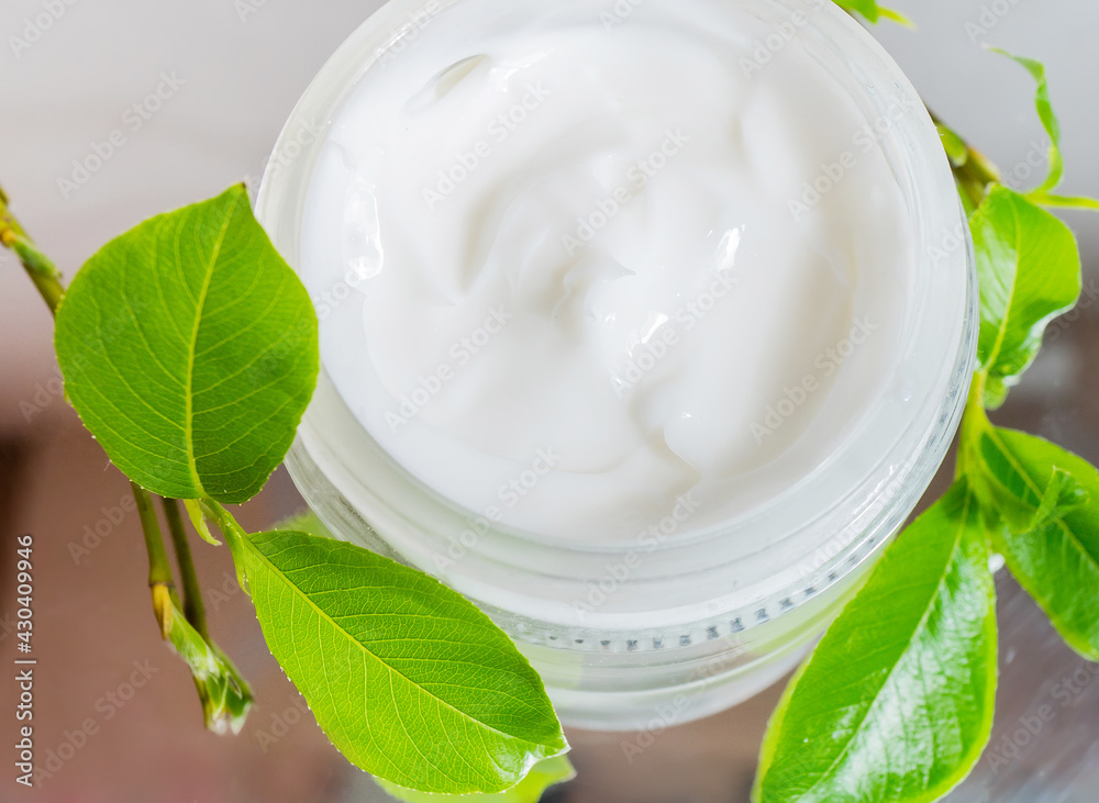Ecologic concept. Hand made cream in glass boutle with green leaves. Zero waste products for personal care Ecologic concept. Hand made cream in glass boutle with green leaves. Zero waste products for personal care