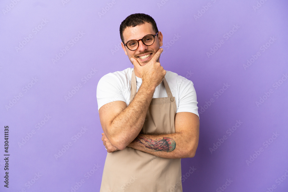 Fototapeta premium Brazilian restaurant waiter over isolated purple background smiling