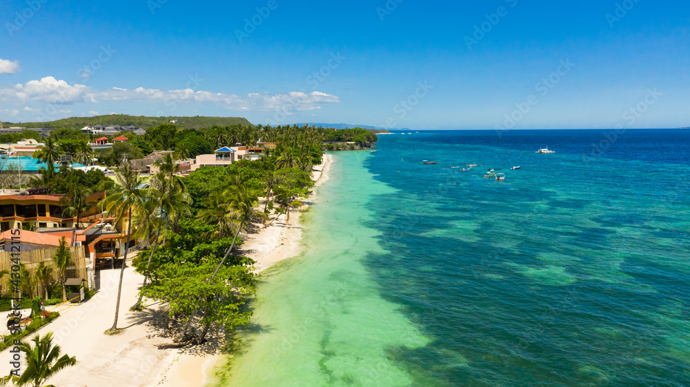 Tropical sandy beach with palm trees and turquoise clear waters. Alona beach, Panglao island, Philippines.