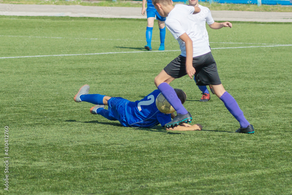 Children's football. Children are playing football. The active struggle and dynamics of the boys' soccer match. The boys are recklessly fighting for the ball Children's football. Children are playing football. The active struggle and dynamics of the boys' soccer match. The boys are recklessly fighting for the ball