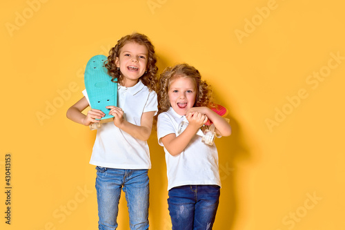 Two Active and happy girls with curly hair having fun with penny