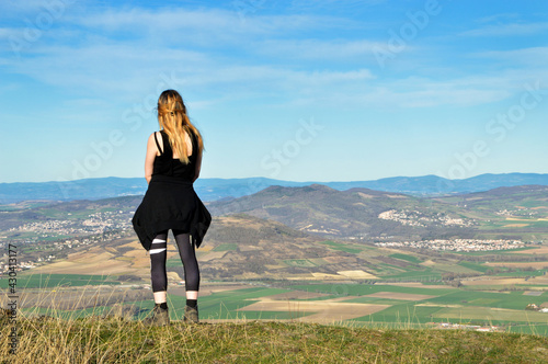 A hiker on top of a mountain with a beautiful view of volcanic mountains