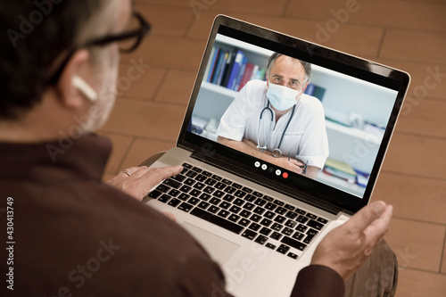 Video chiamata tra un paziente e un medico curante attraverso un computer  in contesto casalingo