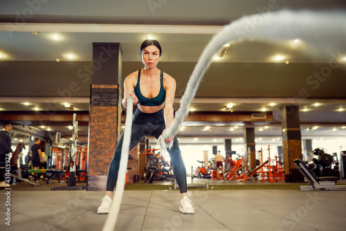 Caucasian fit woman dressed in sportsoutfit doing workout with b