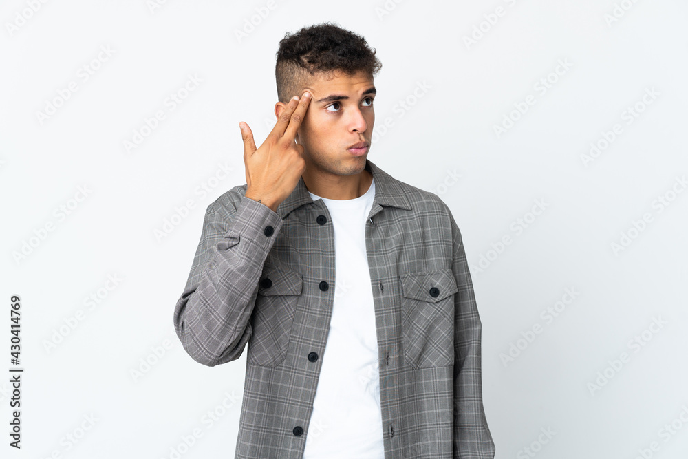 Young brazilian man isolated on white background with problems making suicide gesture Young brazilian man isolated on white background with problems making suicide gesture