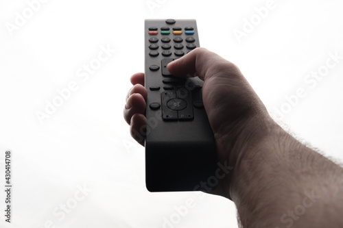 Hand holding tv remote isolated on white background.