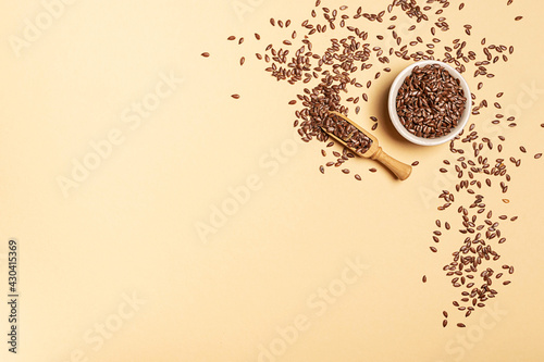 Flax seeds in a jar on yellow background with copy space
