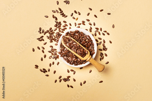 Flax seeds in a jar on yellow background with copy space