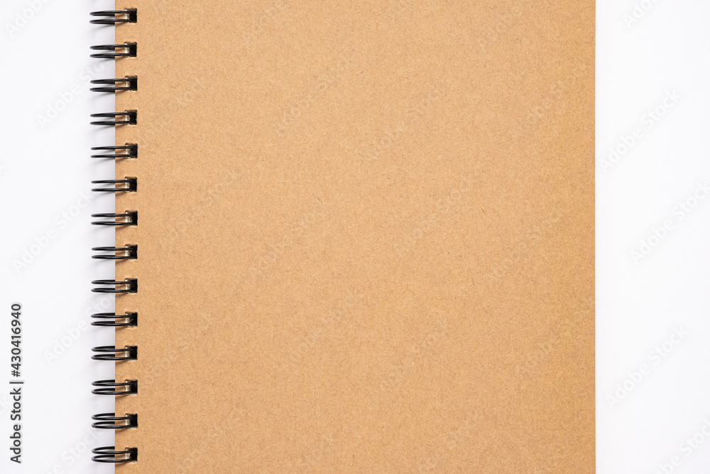 Close up, top view of brown color blank paper cover spiral notebook, copy space for your text. Close up, top view of brown color blank paper cover spiral notebook, copy space for your text.