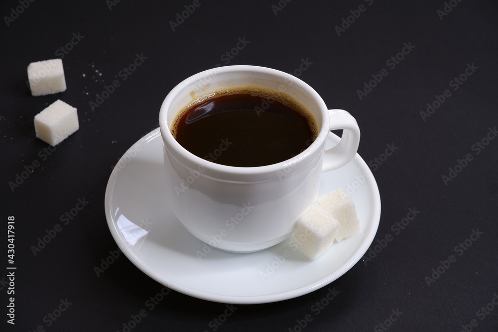 Obraz premium Black coffee and white sugar on a black background.