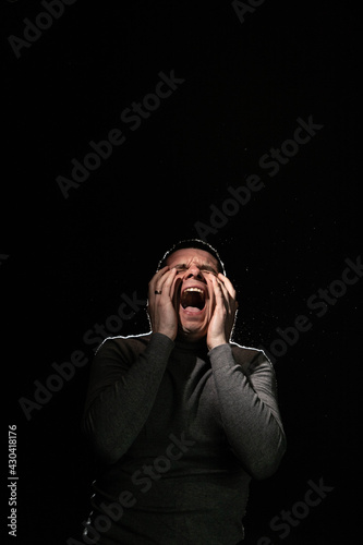 Man screams in horror and covers his face with his hands