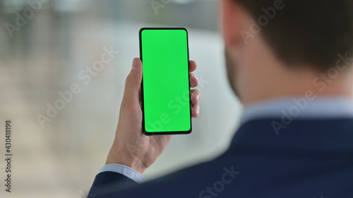 Fotografie Middle Aged Businessman Using Smartphone with Green Chroma Screen